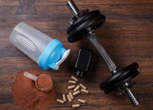 Fitness equipment, weighing scale, measuring tape, healthy foods and water bottle representing weight loss, fat burning, nutrition planning and healthy lifestyle habits.