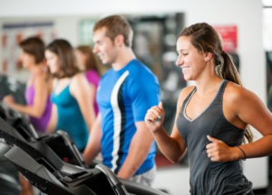 High-energy cardio training at the gym – people running on treadmills after taking a hardcore pre-workout supplement.