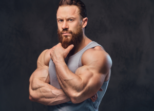 Muscular bodybuilder with developed arms and shoulders showcasing strength, muscle growth, physique enhancement, and advanced bodybuilding conditioning.