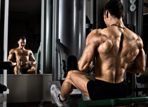 Bodybuilder with developed back muscles training in the gym, focusing on maximum strength and testosterone performance