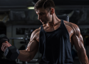 Muscular athlete performing dumbbell curls in the gym while demonstrating the benefits of Agmatine UK 2026 for bigger muscle pumps, enhanced blood flow, improved focus, nitric oxide support, training performance, recovery and nootropic stack optimisation.
