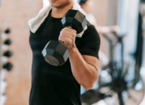 The best DMAA Alternatives in 2026 athlete performing a dumbbell curl during an intense gym workout, demonstrating the type of strength training commonly paired with high-stim pre-workouts, DMHA formulas, and advanced DMAA alternative supplements for energy, focus, and performance.