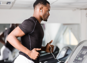 Athlete performing treadmill cardio in a modern gym while wearing earphones and maintaining a focused training pace. Suitable for content covering Crack OG vs Gold vs Purple vs Daily, pre-workout energy, gym motivation, and high-stim supplement comparisons.