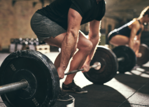 Hardcore pre workout UK athlete performing a heavy deadlift during an intense strength training workout in the gym