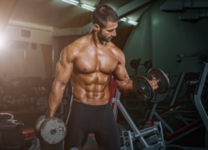 Koka Labz Super Drol RX vs Tren Avar comparison represented by a muscular bodybuilder performing dumbbell curls for mass, strength and hardness.